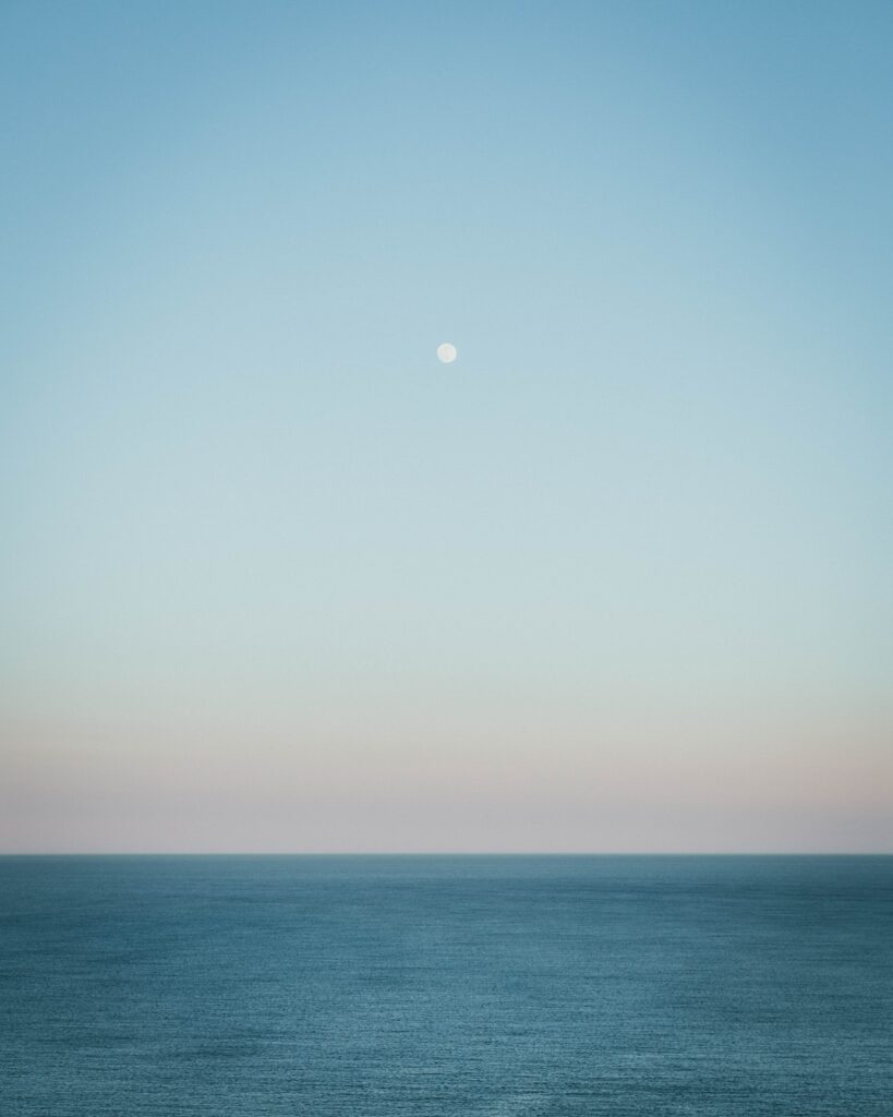 Minimalist calming sea wallpaper with twilight sky pastel hues and a glowing moon background