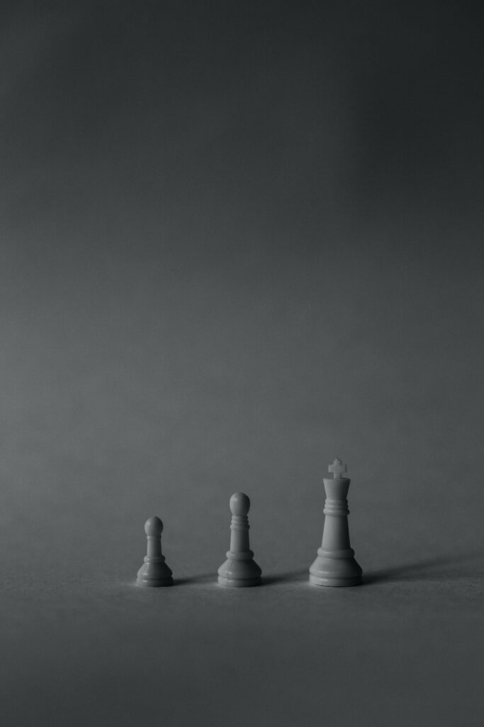 Minimalist Chess Wallpaper: Pawn, Bishop & King on Dark Gray Background