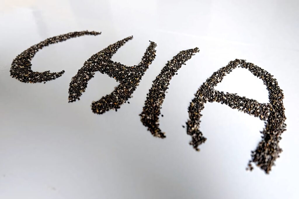 Minimalist wallpaper with the word Chia spelled using real chia seeds on white background