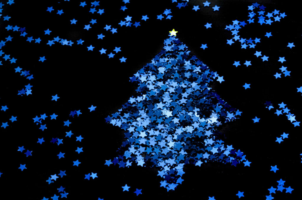 Minimalist Black Background with Blue Star Confetti Christmas Tree Wallpaper