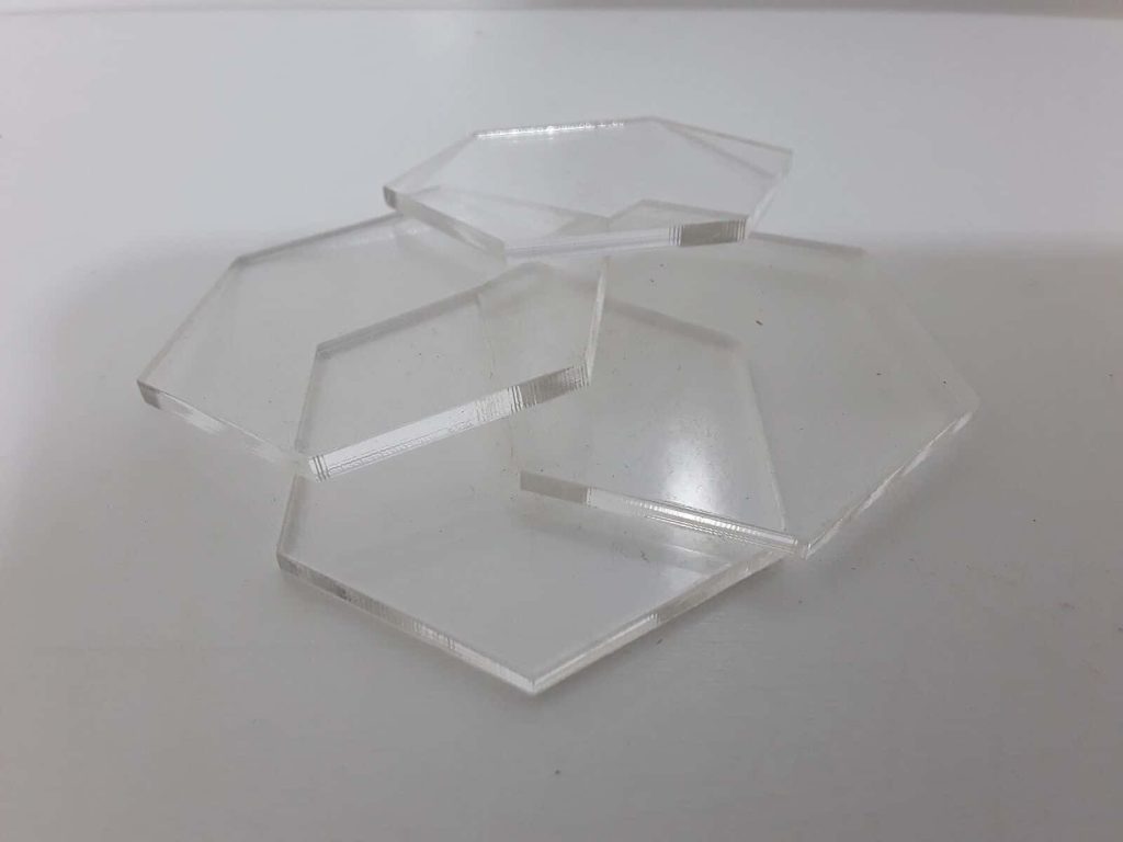 Clear hexagonal acrylic tiles stacked on white surface modern minimalist geometric wallpaper background