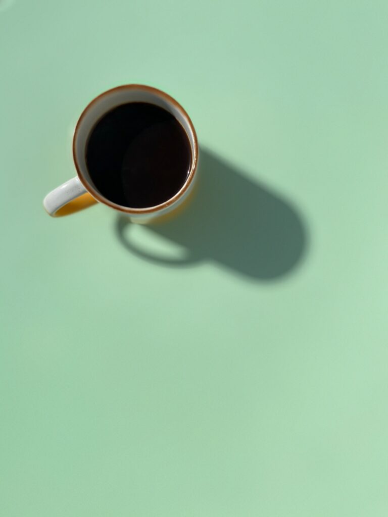 Elegant Minimalist Wallpaper: Coffee Cup Shadow on Light Green