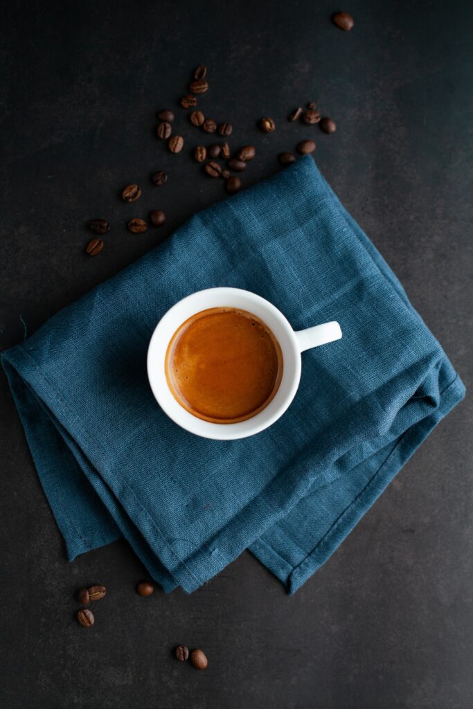 Minimalist Coffee Wallpaper: Fresh Brewed Cup on Blue Cloth
