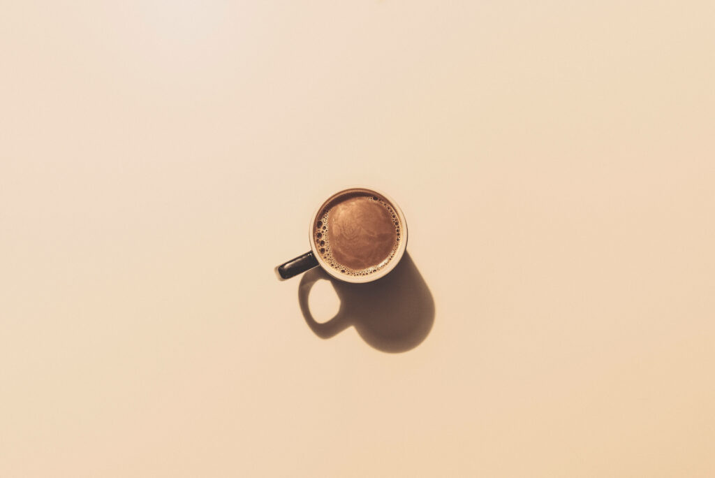 Minimalist Coffee Cup Wallpaper: Soft Shadow on Beige Background