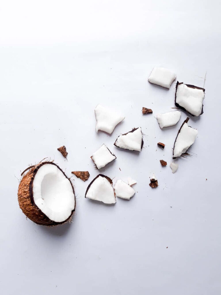 Minimalist wallpaper with cracked coconut brown shell and white flesh on clean white background