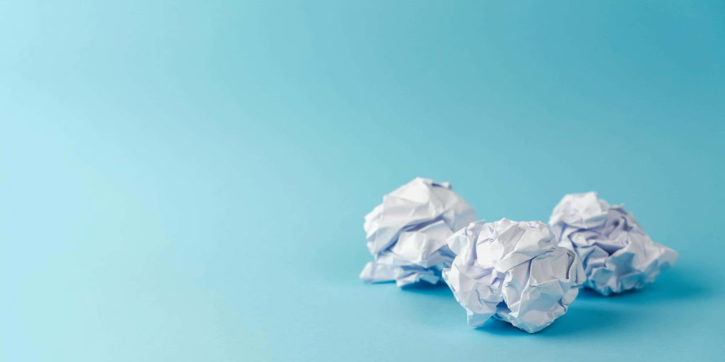 Minimalist crumpled paper wallpaper with three white balls on soft light blue background