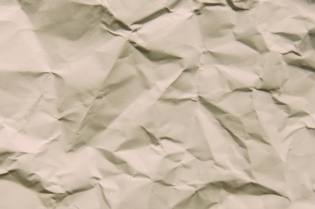 Minimalist macro photo of textured off-white crumpled paper with soft shadows and highlights background Wallpaper