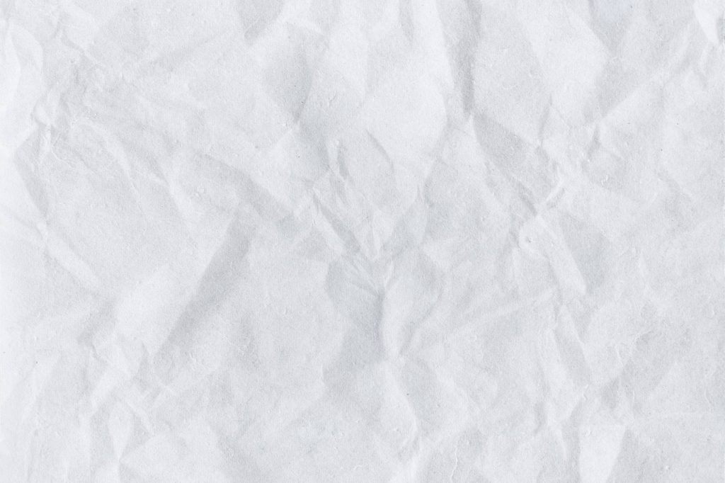 Minimalist crumpled white paper texture with intricate folds and soft natural shadows background Wallpaper