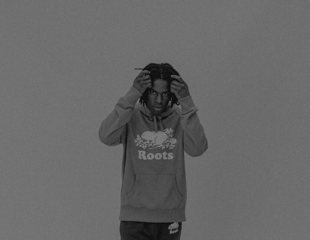Daniel Caesar minimalist wallpaper wearing Roots hoodie against grey background calm mood