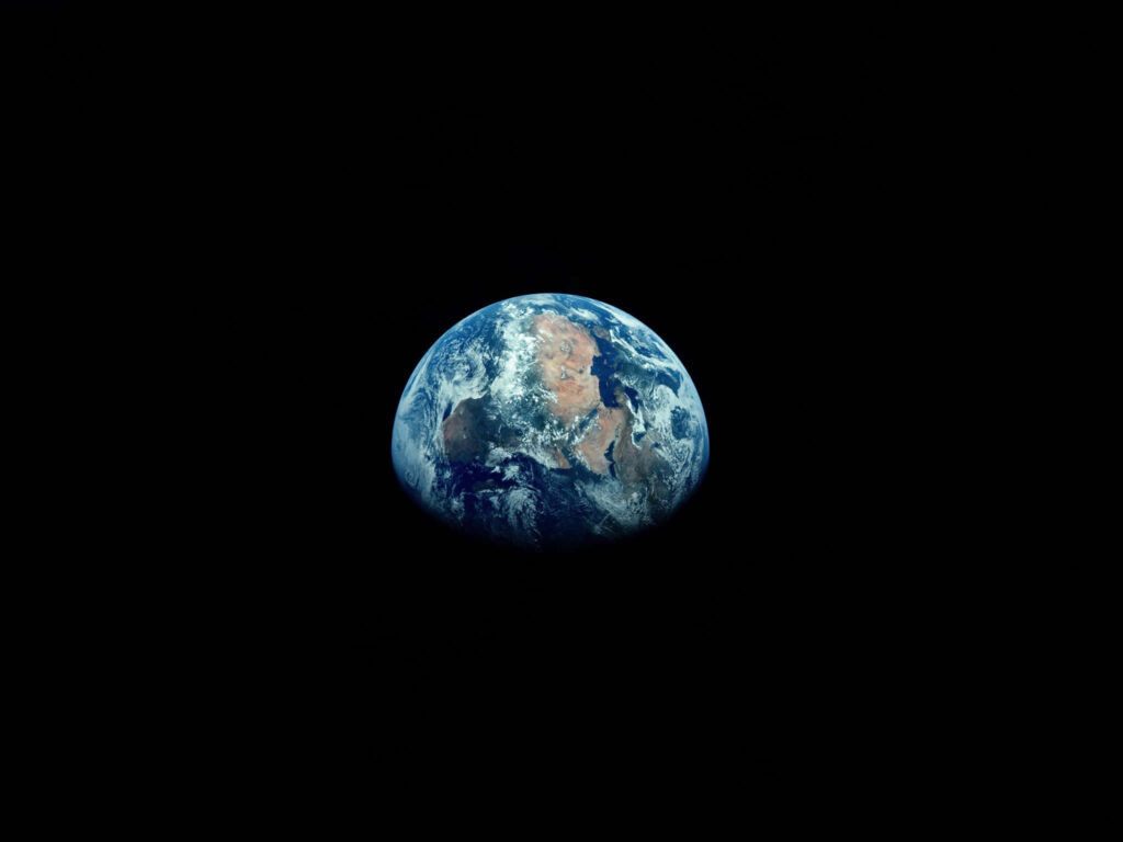 Minimalist wallpaper of Earth in space, showcasing beauty and isolation against a dark void.