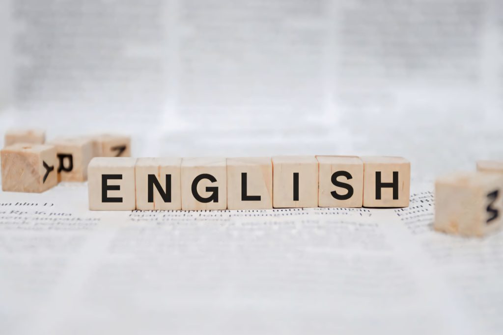 Wooden Scrabble blocks spelling English macro shot blurred text background learning wallpaper