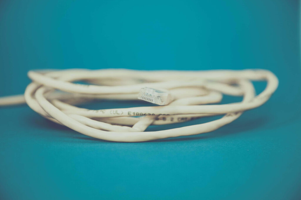 Minimalist teal wallpaper with coiled Ethernet cable showcasing modern tech connectivity design