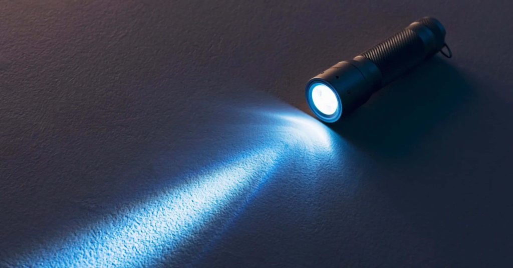 Minimalist flashlight wallpaper with sleek black torch and bright cool light on dark textured background