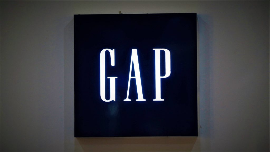 Minimalist Gap logo wallpaper white lettering on deep navy square wall sign modern background