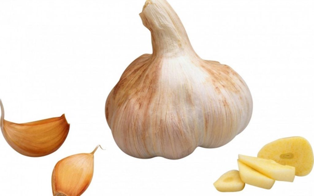 Whole garlic bulb with unpeeled cloves and chopped slices on white background studio photo Wallpaper
