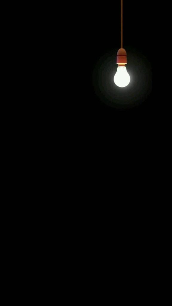 Minimalist glowing light bulb on pure black background AMOLED wallpaper for energy efficiency