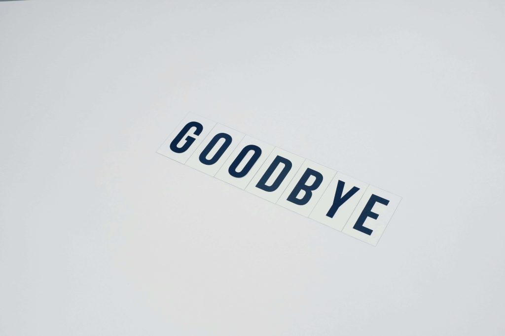 Minimalist wallpaper with dark blue GOODBYE letters on white tiles diagonal light grey background