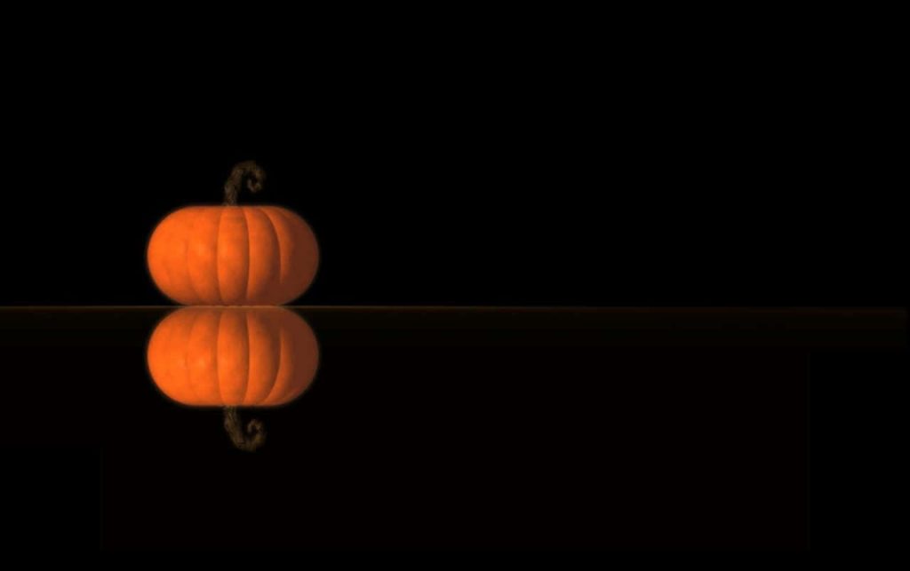Halloween pumpkin reflection wallpaper with vibrant orange pumpkin on black background