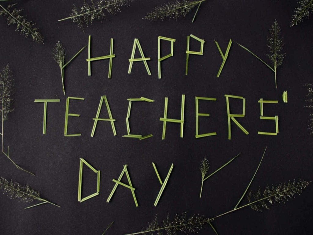 Happy Teachers Day card with green plant stem text on dark textured natural background flat lay Wallpaper