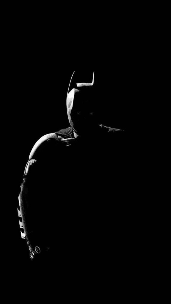 Minimalist Batman wallpaper with high-contrast rim lighting on pure black OLED background