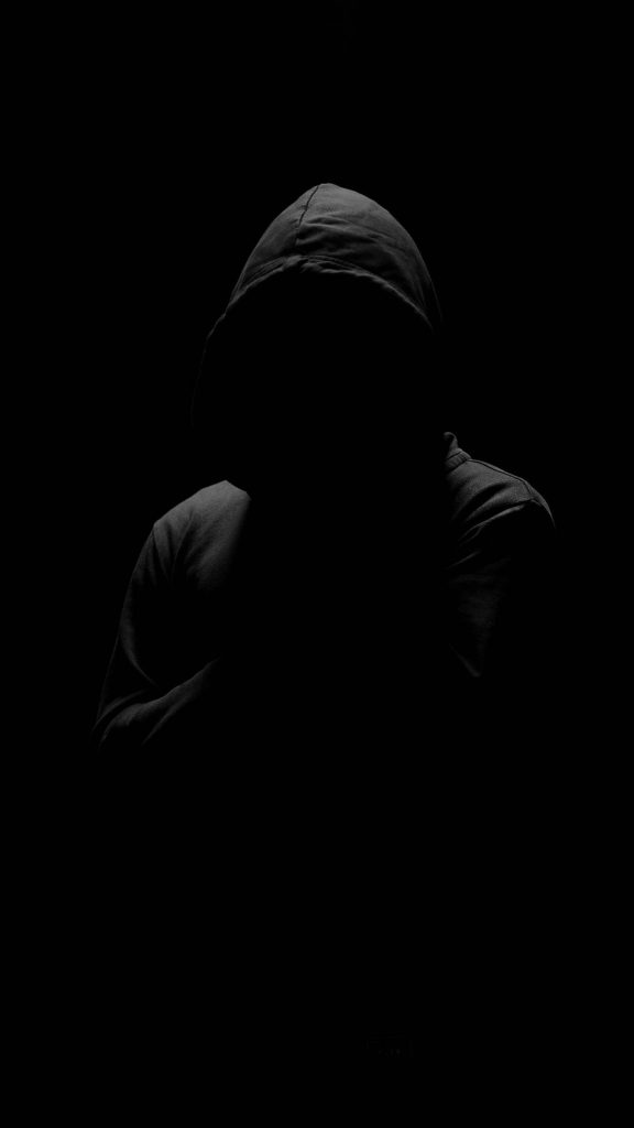 Minimalist mobile wallpaper of a mysterious hooded figure silhouette on deep black OLED background
