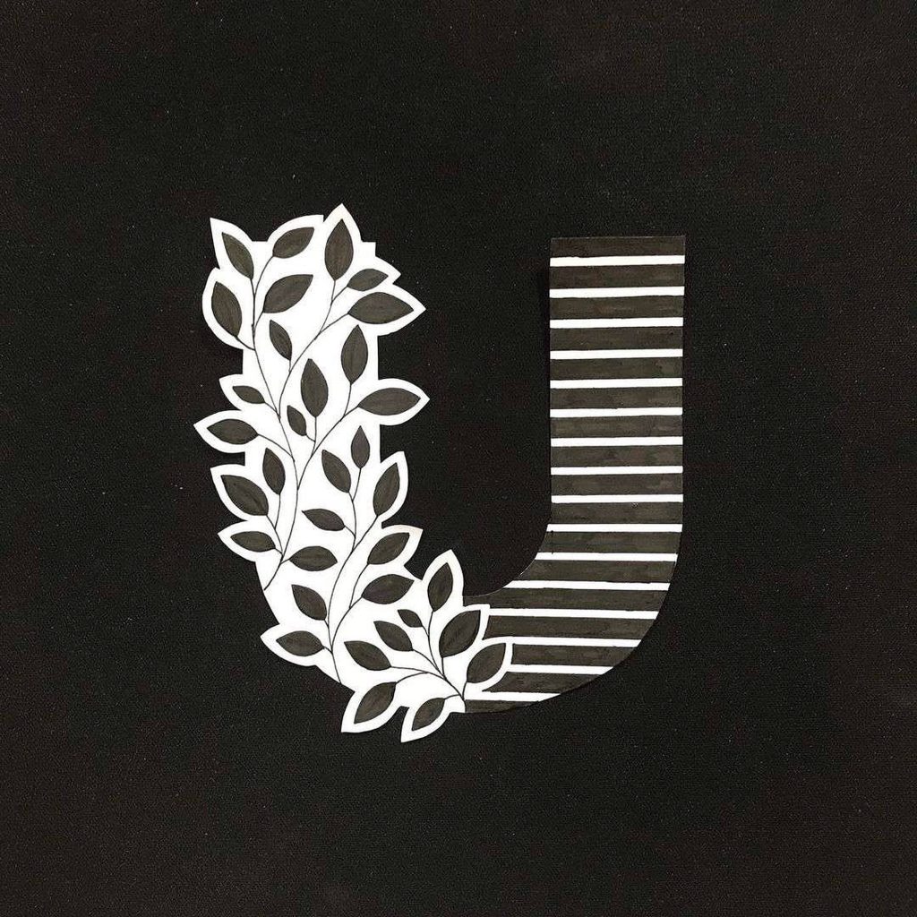 Minimalist letter U wallpaper with black white leaf patterns left and stripes right on black background
