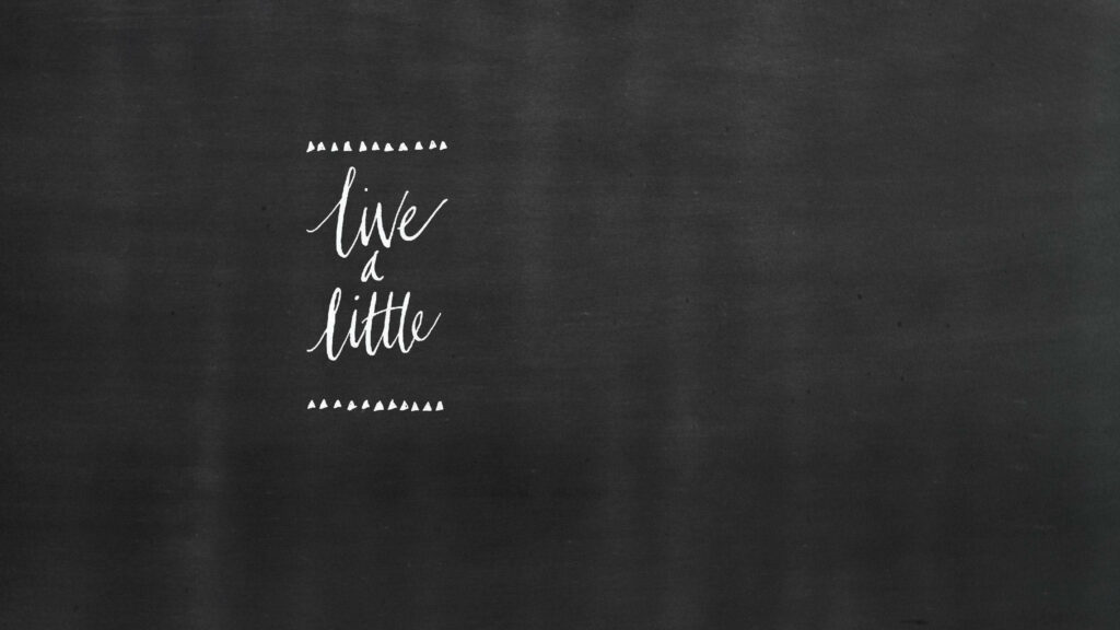 Minimalist chalkboard wallpaper with live a little handwritten phrase on dark textured background