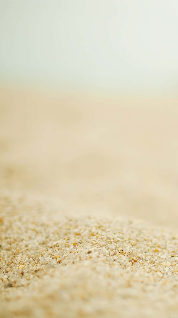 Close-up of sharp sand grains with creamy blurred background warm earthy beach tones wallpaper