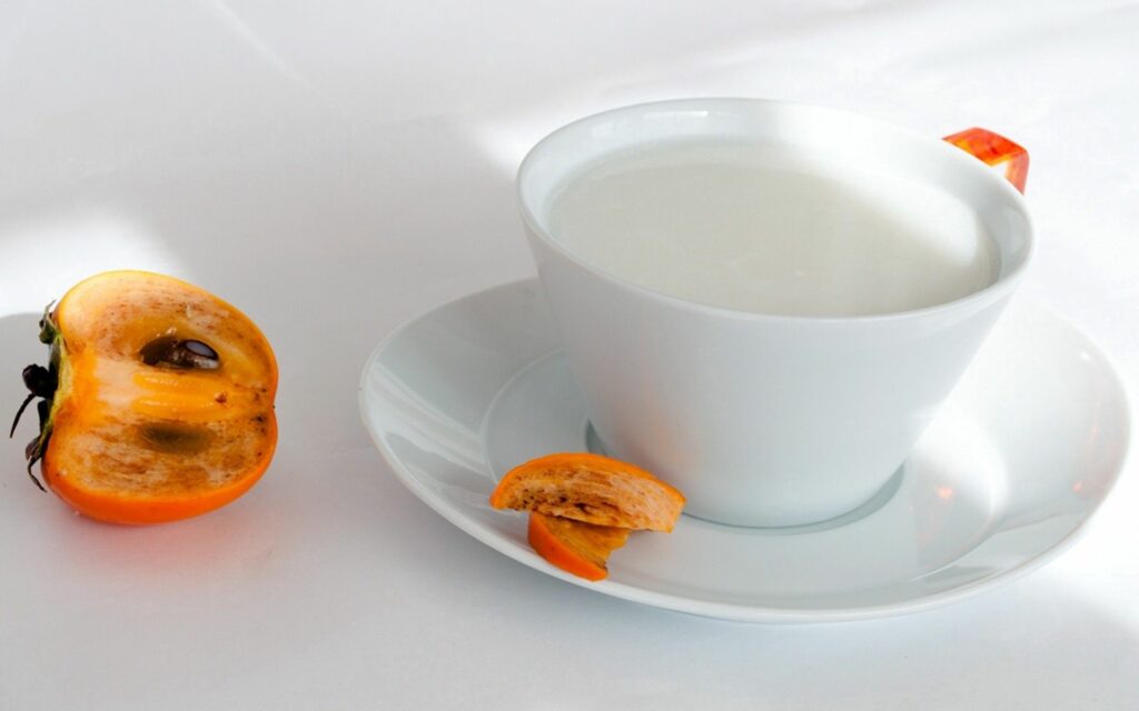 Minimalist Milk Cup & Persimmon on White Table – Wallpaper Inspiration