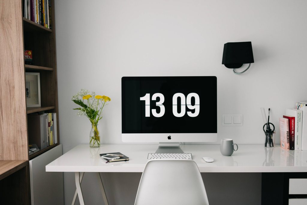 Minimalist office Zoom background with iMac desk digital clock yellow flowers modern workspace Wallpaper