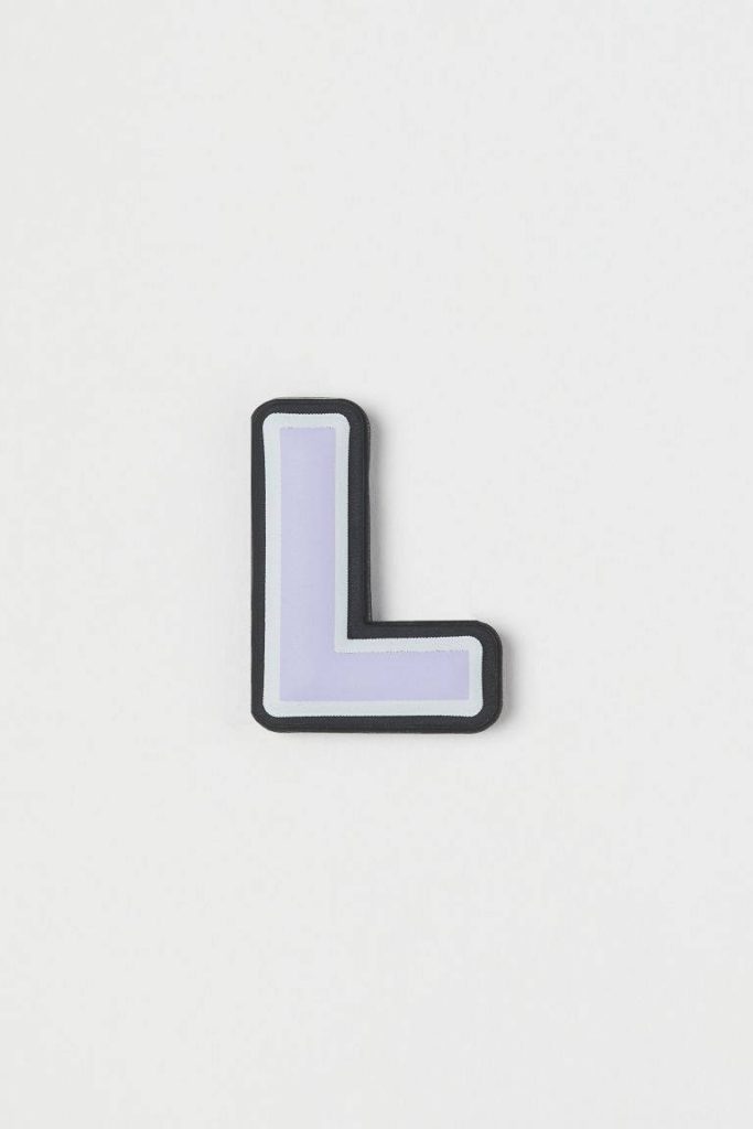 Minimalist pastel purple letter L wallpaper with bold dark outline on off-white background