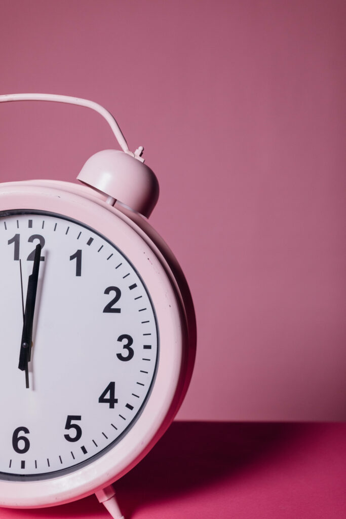 Pink classic alarm clock on soft pink background minimalist style retro charm wallpaper