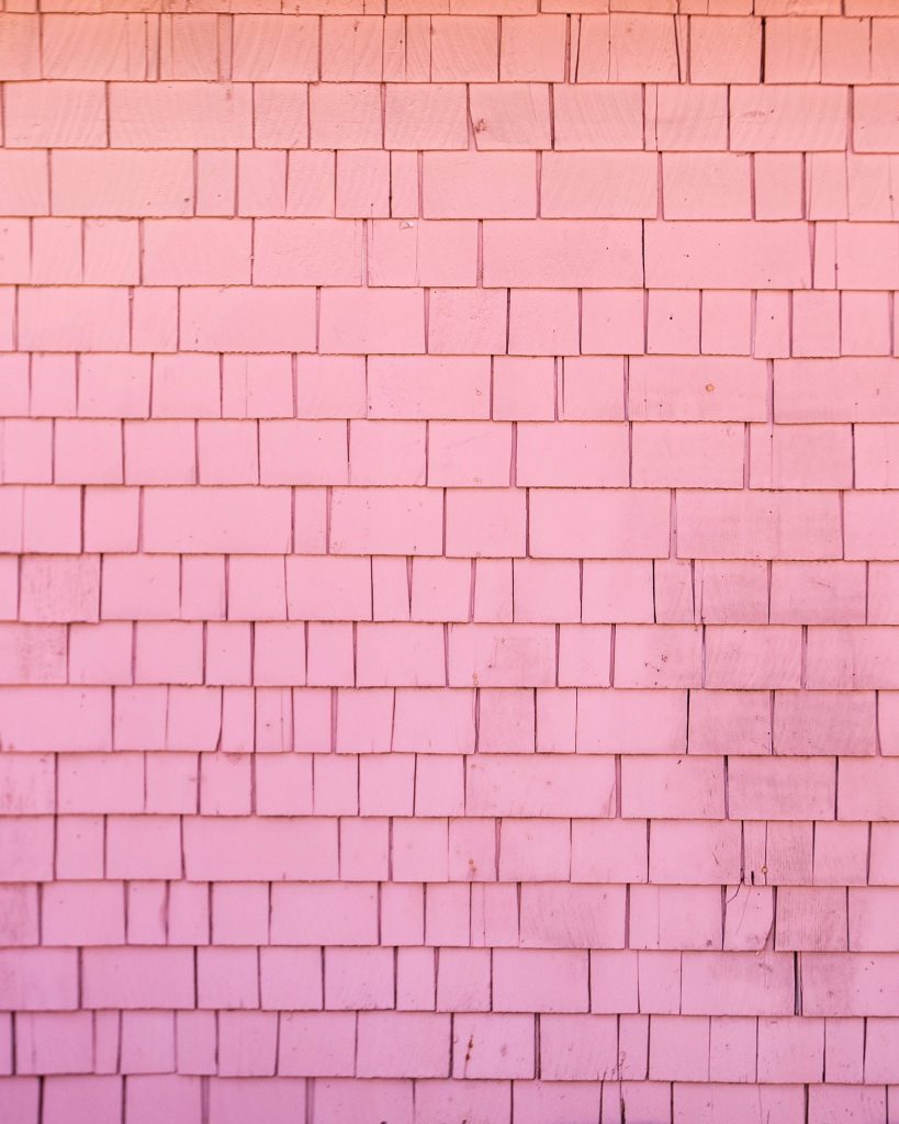 Minimalist rustic wooden shingle wall wallpaper in soft pinks with textured rectangular pattern