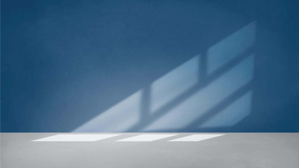 Minimalist professional Zoom background deep blue wall neutral floor sunny window shadows Wallpaper
