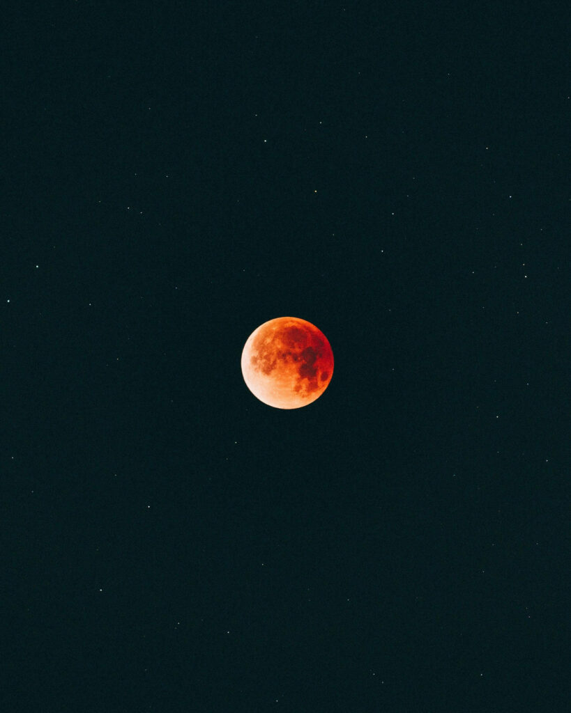 Elegant Minimalist Wallpaper: Striking Red Moon on Dark Starry Background