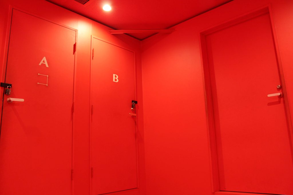 Minimalist red room with locked doors A and B dramatic lighting surreal modern wallpaper background