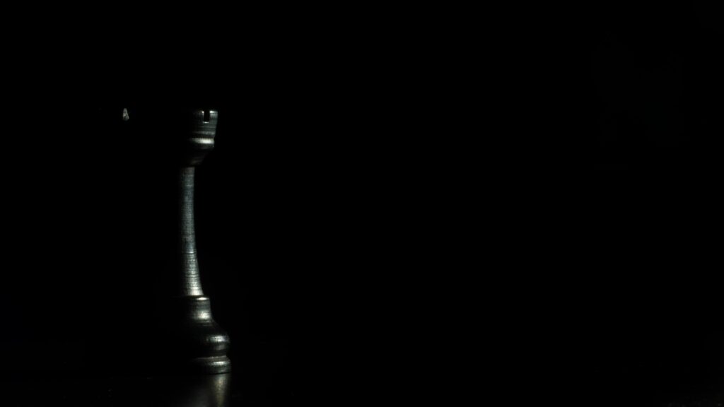 Elegant Minimalist Wallpaper: Black Rook Chess Piece on Dark Background