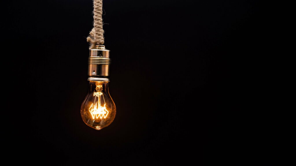Suspended Minimalism: Rope-Adorned Bulb Radiates 4K Ambiance Wallpaper