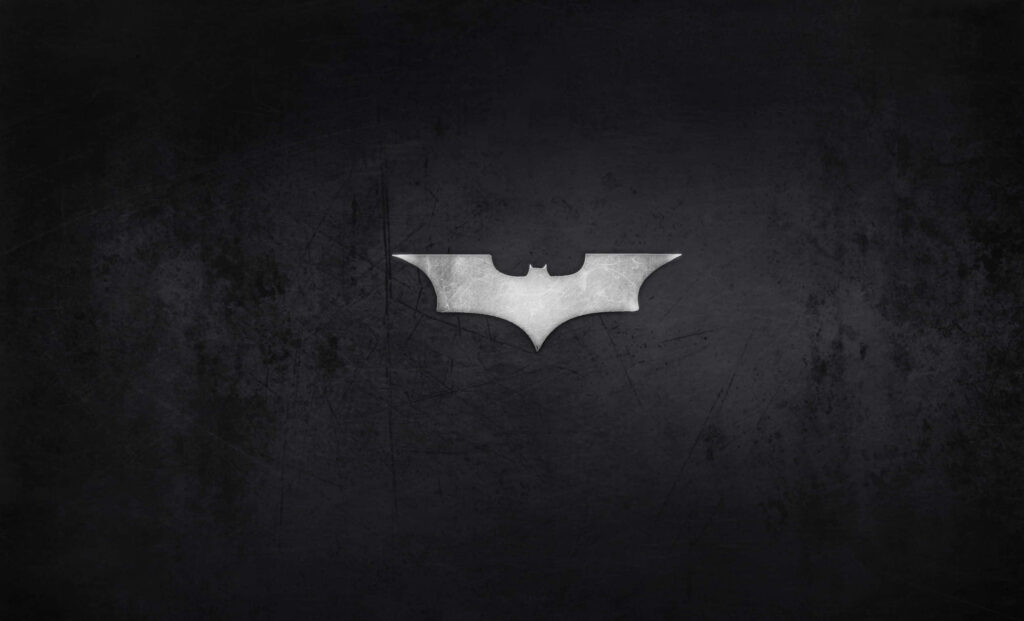 Minimalist silver Batman logo on textured dark background sleek modern superhero wallpaper