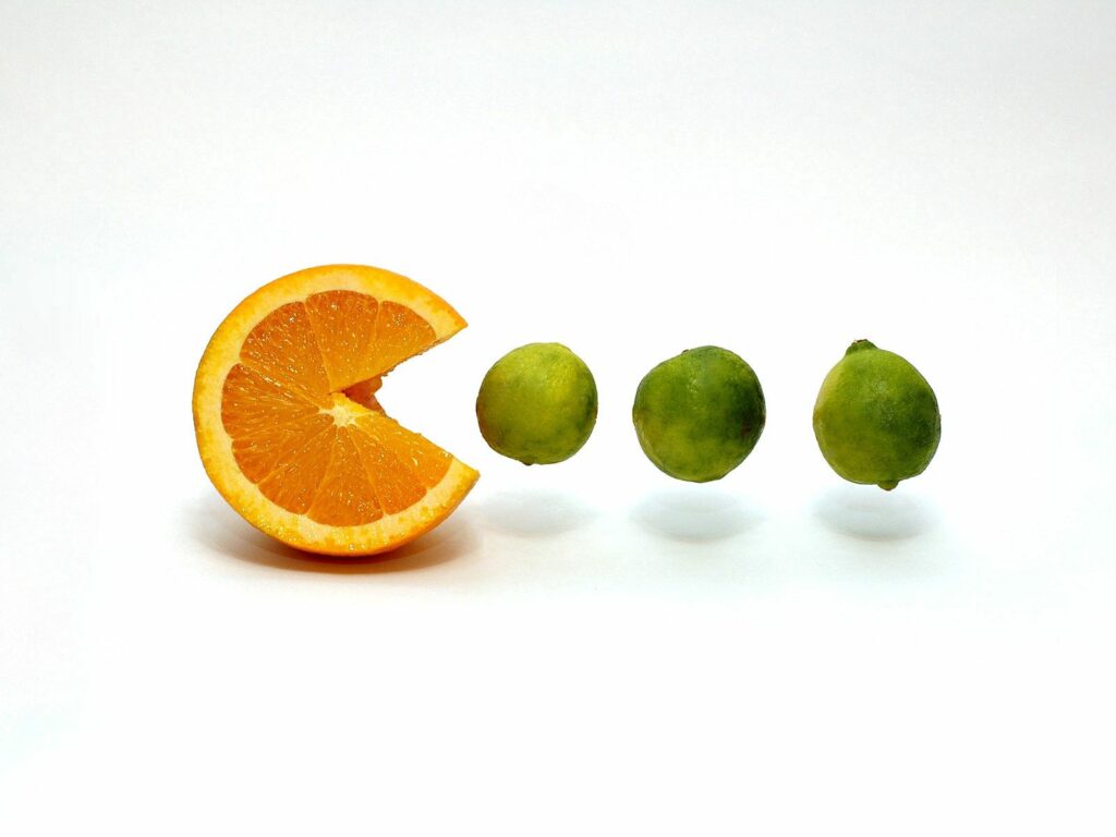 Minimalist Pac-Man Orange Wallpaper: Fun Lime Design on White Background