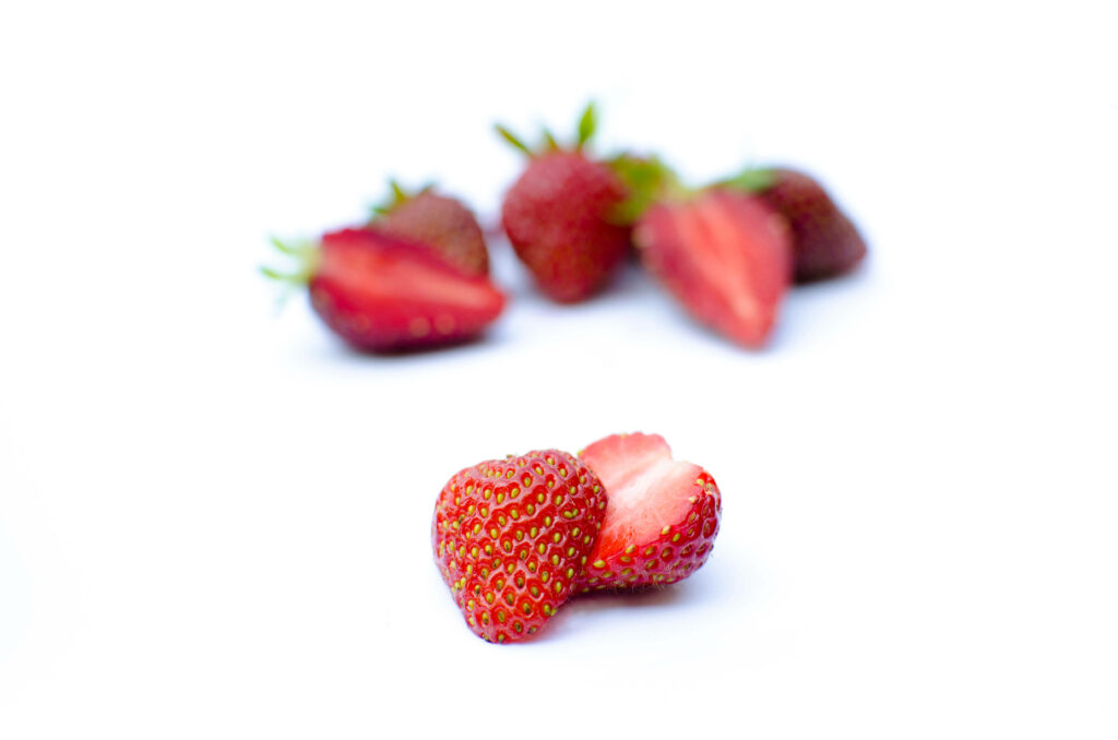 Minimalist Strawberry Wallpaper: Fresh Sliced Berries on White Background