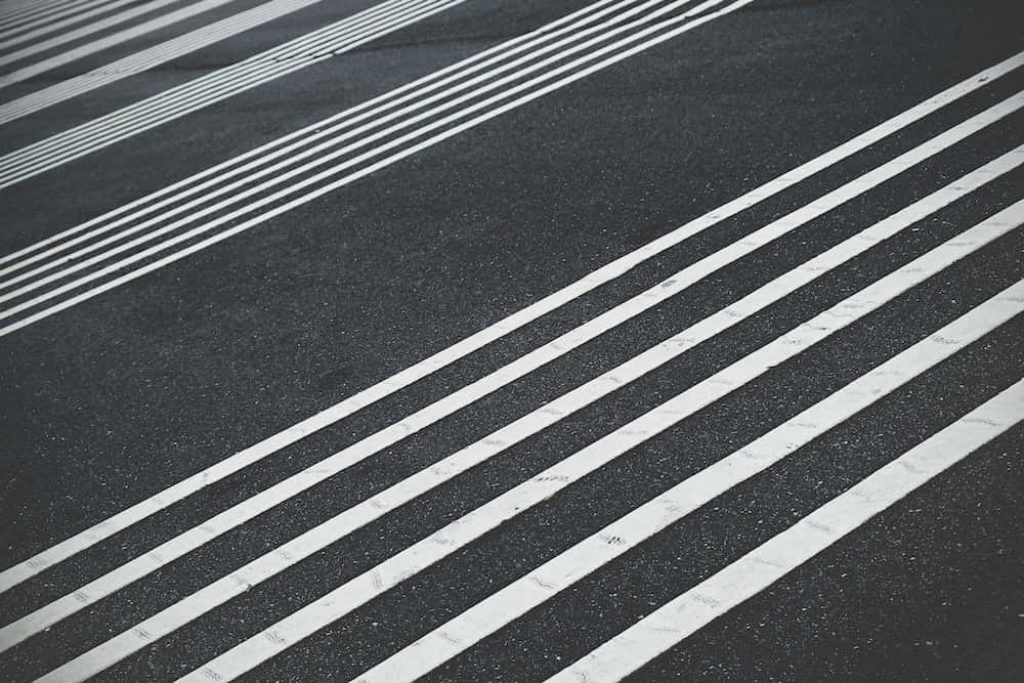Striped asphalt road with bold white lines diagonal composition modern minimalist wallpaper background