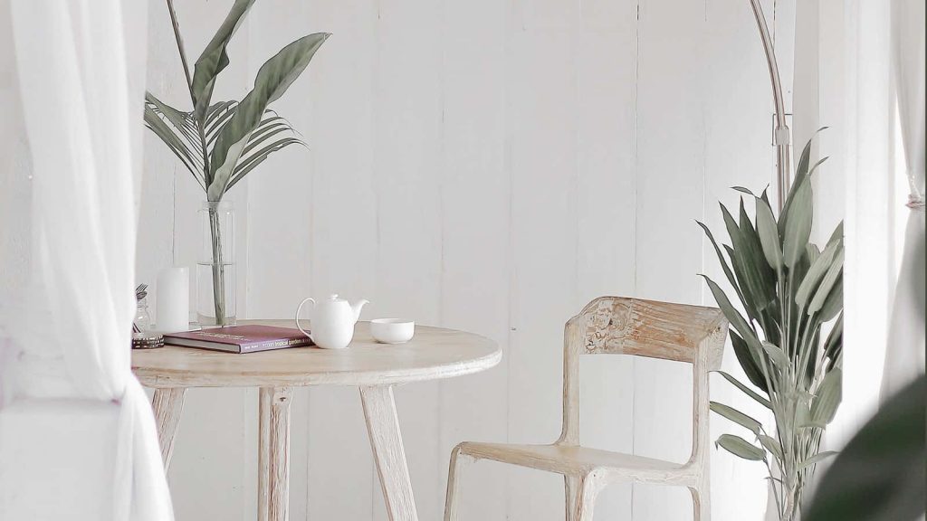 Minimalist sustainable Zoom background with light wood table tea set and lush green plants Wallpaper