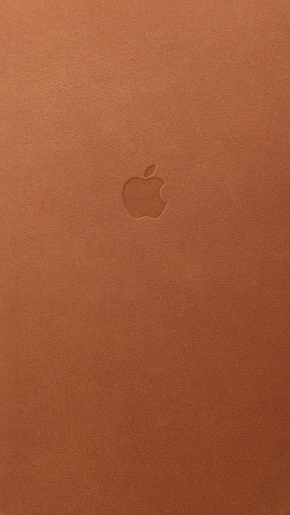 Minimalist wallpaper with embossed Apple logo on warm tan leather texture for stylish devices