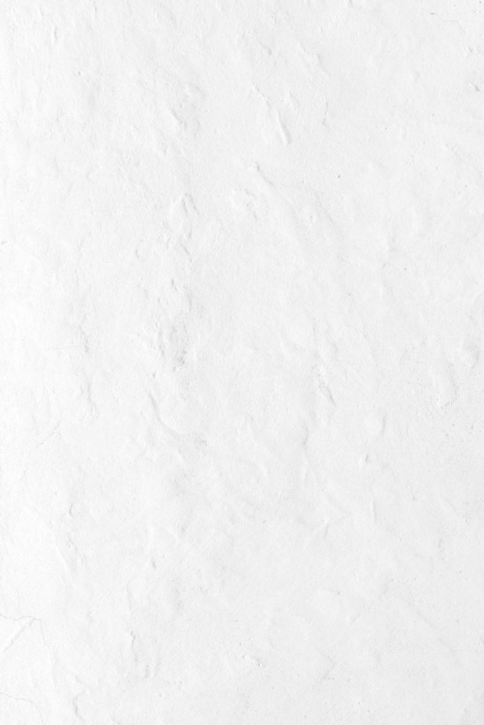 Minimalist textured white wall background with subtle plaster details and soft diffused light Wallpaper