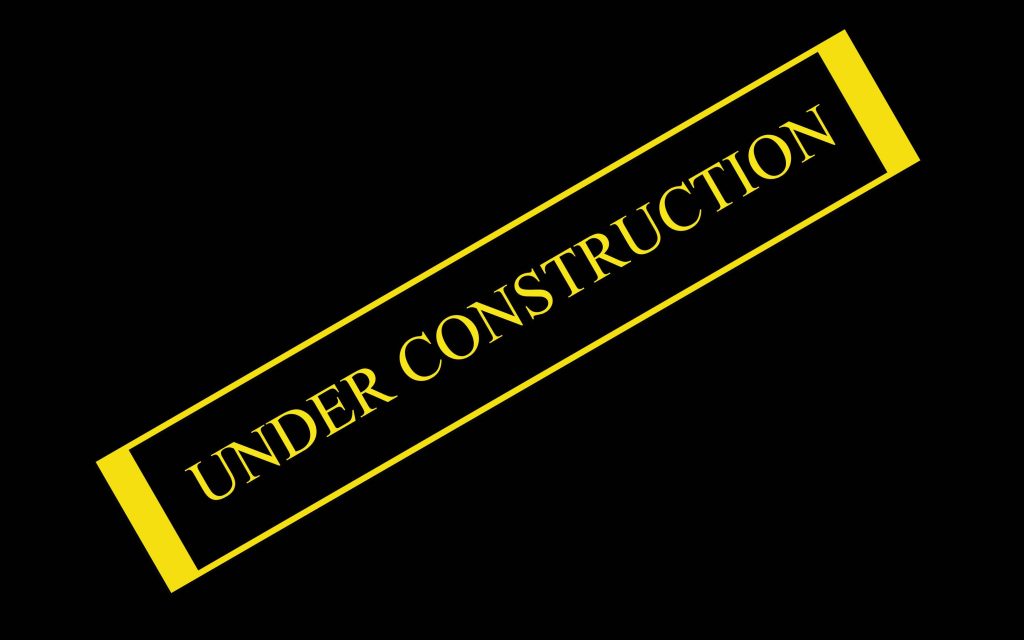 Minimalist under construction wallpaper with bold white text in yellow frame on black background
