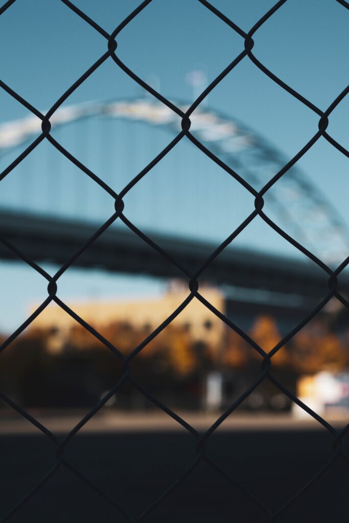 Urban Bridge Blurred Wallpaper with Focused Chain-Link Fence