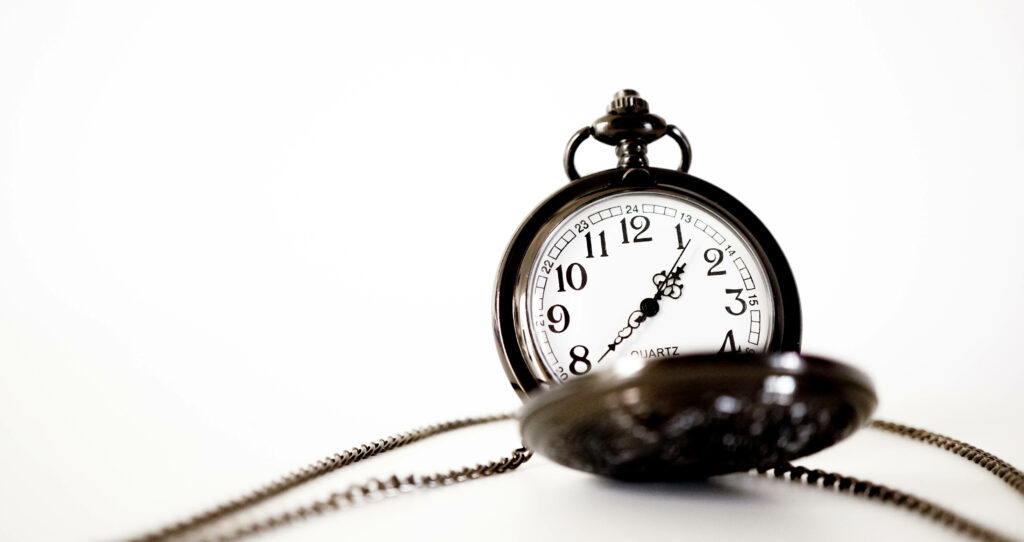 Vintage pocket watch with detailed chain on minimalist white background elegant wallpaper