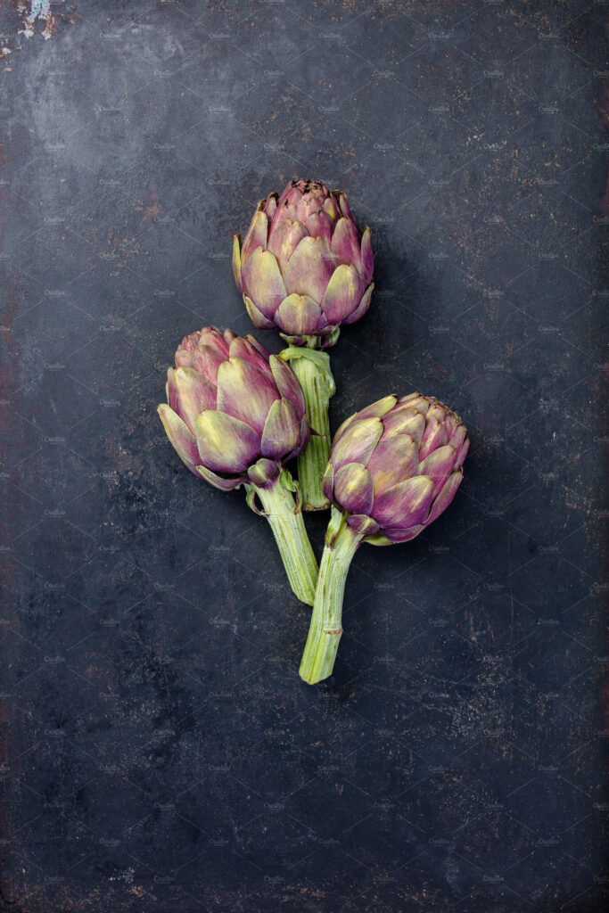 Minimalist wallpaper with three petite violet artichokes on dark textured background natural beauty