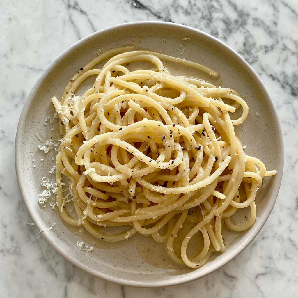 Minimalist Cacio e Pepe Wallpaper: Creamy Pasta on Marble Surface